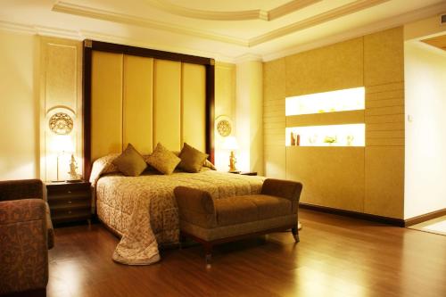 a bedroom with a bed and a chair at LK Residence in Pattaya Central