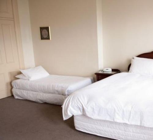 a hotel room with two beds and a table at The Hotel Shamrock in Bendigo