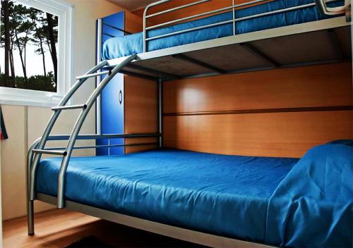 a bedroom with two bunk beds and a window at Parque de Campismo Orbitur Angeiras in Angeiras