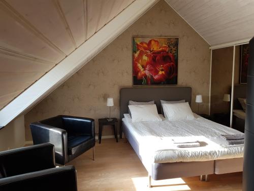 a bedroom with a bed and a chair in a attic at Villa Rosenlund in Malmö