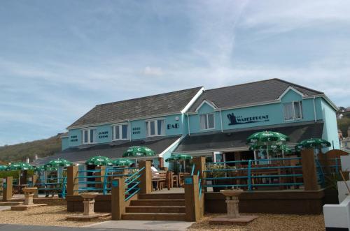a building with green umbrellas in front of it at The Waterfront Inn in Westward Ho