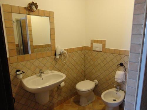a bathroom with a sink and a toilet and a mirror at Bed and Breakfast Ichnos in Cala Gonone