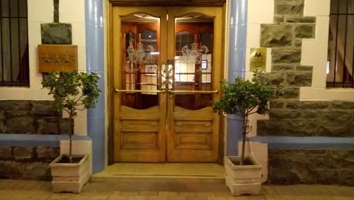 a wooden front door of a building with two potted plants at Royal Hotel Ladysmith in Ladysmith