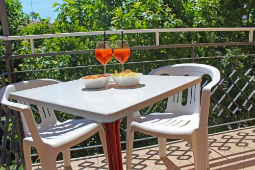 a table with two wine glasses and two chairs at Hotel Silvia in Misano Adriatico