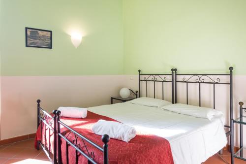 a bedroom with a bed with a red blanket at Domus Sessoriana in Rome