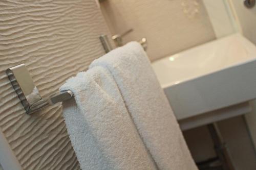 a bathroom with a white towel hanging on a towel rack at Hotel Touring in Misano Adriatico
