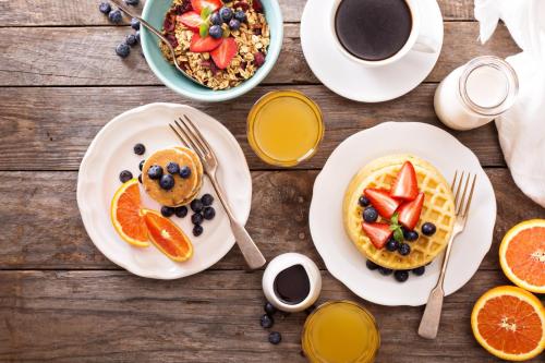 a table with plates of breakfast foods and a cup of coffee at Holiday Inn Bandung Pasteur by IHG in Bandung
