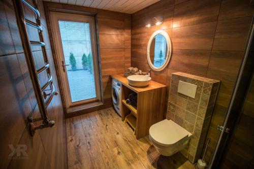 uma casa de banho com um WC, um lavatório e um espelho. em Maria Apartments em Tartu