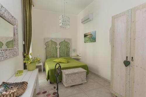 a bedroom with a green bed in a room at Merydamy in Mattinata