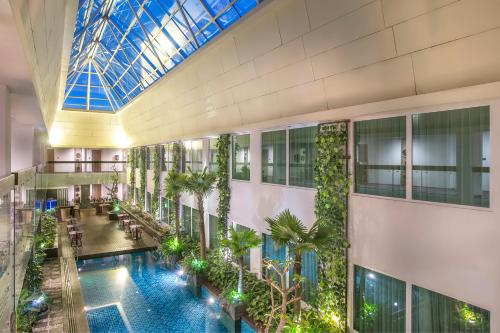 Holiday Inn Bandung Pasteur في باندونغ: مسبح داخلي في مبنى به منور