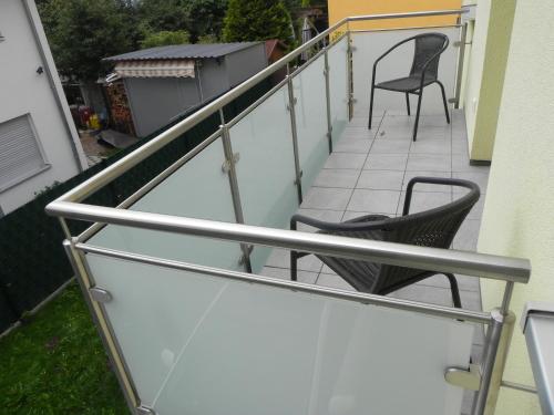 a railing on a balcony with two chairs at 1-Zimmer-Wohnung Nähe Playmobil Funpark in Oberasbach