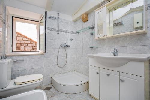 a white bathroom with a sink and a toilet at Villa Leora Dubrovnik in Dubrovnik