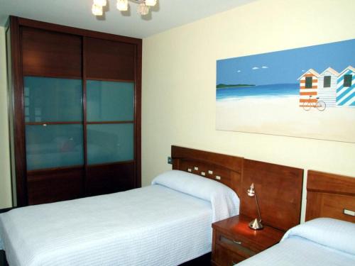 ヒホンにあるVivienda en Gijon frente al marのベッドルーム1室(ベッド2台付)が備わります。ビーチの写真を用意しています。