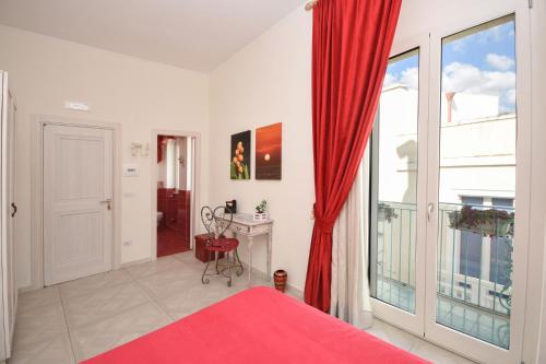a bedroom with a red bed and a large window at Merydamy in Mattinata