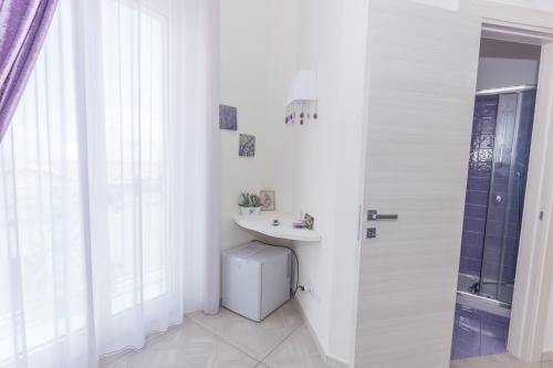 a white bathroom with a sink and a shower at Merydamy in Mattinata