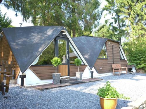 GesvesにあるAlluring Chalet in Gesves with Roof Terrace Garden BBQの大黒いカバーの家