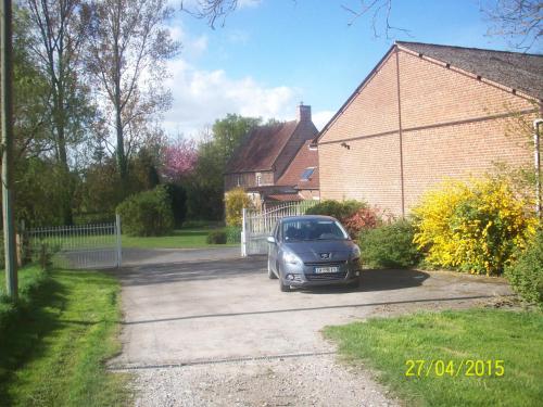a car parked in the driveway of a house at Le moulin de Cohem in Blaringhem
