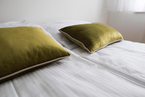 a white bed with two pillows on it at Turistic Apartments Centar Sarajevo in Sarajevo