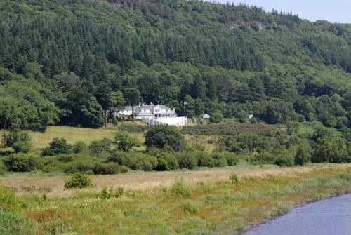 a house on a hill next to a river at Plas Maenan in Conwy