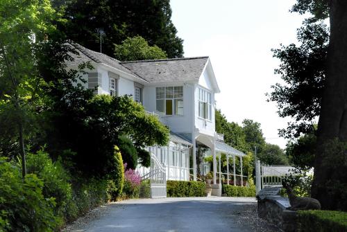 a white house with a driveway at Plas Maenan in Conwy