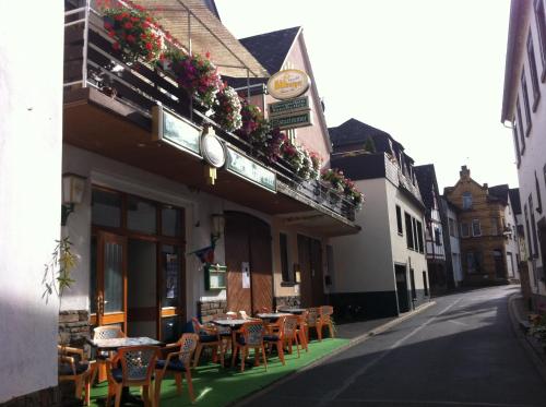 ein Restaurant mit Tischen und Stühlen auf einer Straße in der Unterkunft Zur Burg Eltz in Moselkern