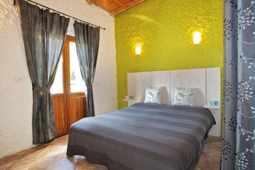 a bedroom with a bed and a yellow wall at Agriturismo OlivArancio in Leivi