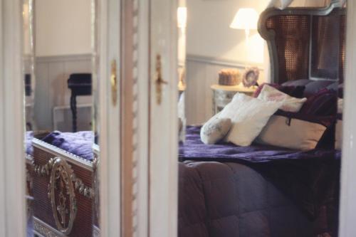 a bedroom with a bed with pillows on it at Le Bonheur à la Campagne in Lesmont