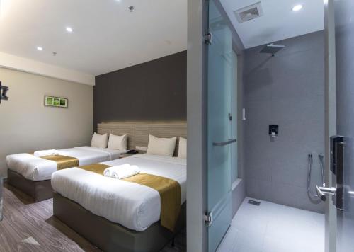 八打灵再也Hotel 99 Kelana Jaya (PJ)的酒店客房设有两张床和淋浴。
