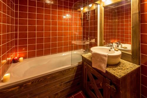 a bathroom with a tub and a sink and a bath tub at Chalet de l'Ours in Arc 2000