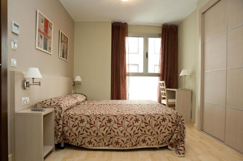 Una habitación de hotel con una cama y una ventana. en Arcohotel, en San Mateo de Gállego