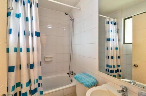 a bathroom with a shower curtain and a sink at Departamento Mondaca Vista Mar in Valparaíso
