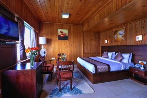 a bedroom with a bed and a desk and a television at Zone Connect by The Park Mount Siniolchu, Gangtok in Gangtok