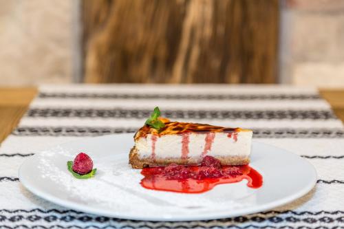 a piece of cake on a plate with a strawberry at Dacii Liberi Resort and Spa in Petrova