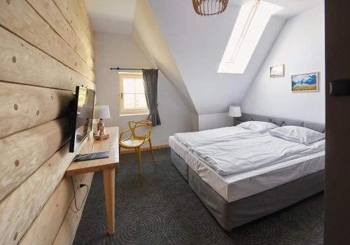 a bedroom with a bed and a table and a desk at Hotel Gazdówka Spa in Osielsko