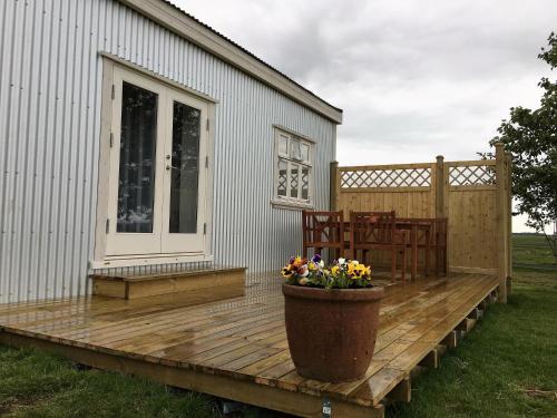 a wooden deck with a table and chairs on a house at Gamla Húsið - The Old House in Selfoss