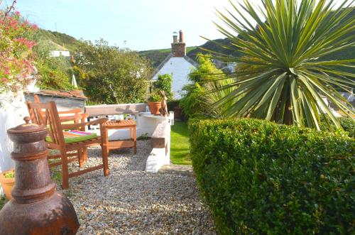 a garden with two chairs and a bush at The Gallery in Port Isaac