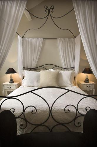 - une chambre avec un grand lit et des rideaux blancs dans l'établissement Auberge 's Gravenhof, à Fourons