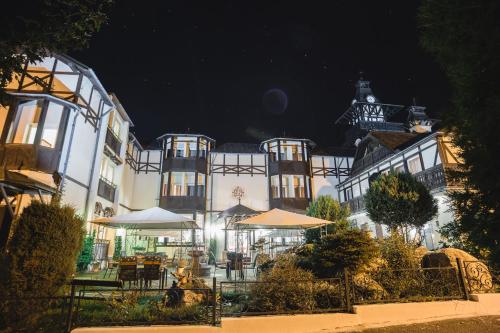 a building with tables and umbrellas in front of it at Schlosshotel Marienbad in Mariánské Lázně