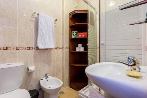 a bathroom with a white sink and a toilet at Cegonha do mar in Aljezur