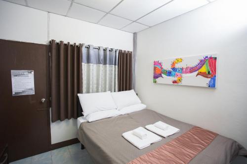 a bedroom with a bed with two towels on it at Zzhouse in Chiang Mai