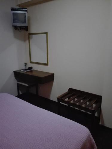 a bedroom with a bed and a desk and a mirror at Estalagem Corte do Norte in Ponta Delgada