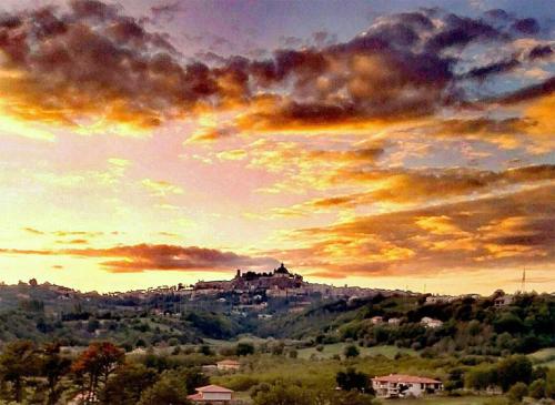 a painting of a castle on a hill at sunset at La Baronessa Country House in Montefiascone