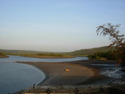 a campsite on the beach next to the river at Barve Homes in Ratnagiri