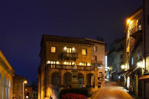 an old building with a balcony on a street at night at Hotel Titano in San Marino