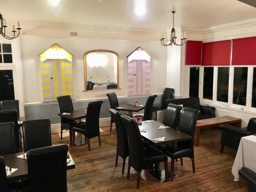 comedor con mesas, sillas y espejo en Blyth Hotel, en Southwold