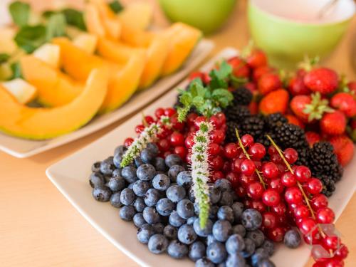 two plates of fruits and vegetables on a table at Hochwald Hotel & Apartment in Bad Liebenzell