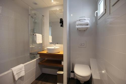 a bathroom with a sink and a toilet and a mirror at Best Western Hotel De Paris in Laval