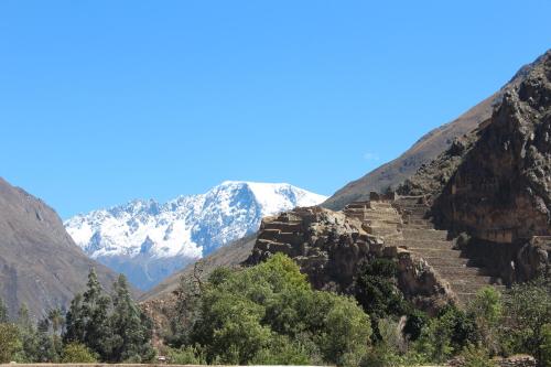 a stairway up a mountain with snow covered mountains at Hotel Tierra Inka Sacred Valley in Ollantaytambo