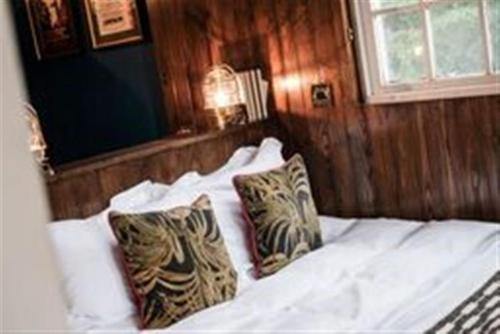 ein Schlafzimmer mit einem weißen Bett mit zwei Kissen in der Unterkunft The Pilot Inn in London