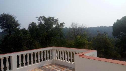 a white balcony with a view of the mountains at Barve Homes in Ratnagiri